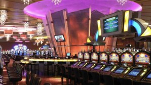 Un casino con múltiples máquinas tragamonedas y una zona de bar.