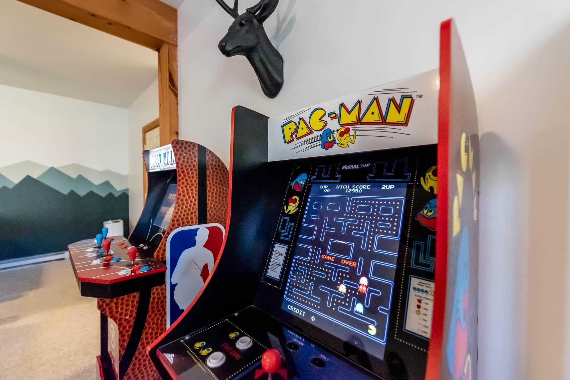 Een Pac-Man spelautomaat met een digitaal scherm, een joystick en een muntinworp.