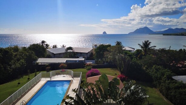 Une piscine avec vue sur la mer et les montagnes en arrière-plan.