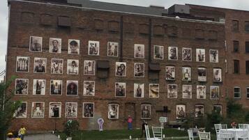A brick building with multiple framed photographs on its facade.