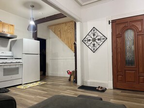 A kitchen with a stove, refrigerator, and hanging pendant light. - Hudson Valley Mid Hudson Newburgh (Newburgh)
