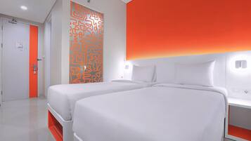 Habitación de hotel con dos camas, una decoración en blanco y naranja y un diseño moderno.