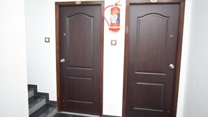 Dos puertas de madera con un extintor instalado entre ellas.