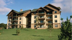 A multi-story hotel with a modern architectural design, featuring balconies and large windows. - Great Smokey Mountains Resort - Pigeon Forts Condo  (Pigeon Forge)
