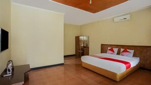 Ein Hotelzimmer mit einem großen Bett, einem Schreibtisch und einem Fernseher.
