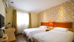 A hotel room with two beds, a desk with a computer, and a wall with a polka dot pattern. - Home Inn Hotel Beijing Tongzhou Xinhua South Road (Tongzhou)