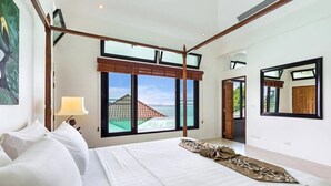 A spacious bedroom with a large bed, a view of the sea, and a netted structure outside the window. - Luxury Beachfront Tai Pan Villa (Wichit)