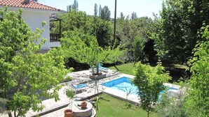 Ein Garten mit Pool, überdachter Sitzgruppe und einem Haus.