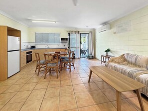 Un espacio habitable compacto con cocina, comedor y sofá.