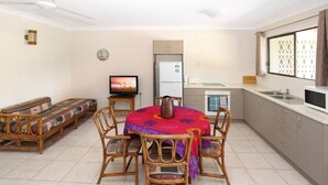 Un espace de vie compact comprenant un coin repas, une kitchenette et un canapé.
