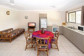 Un espacio habitable compacto con comedor, kitchenette y sofá.