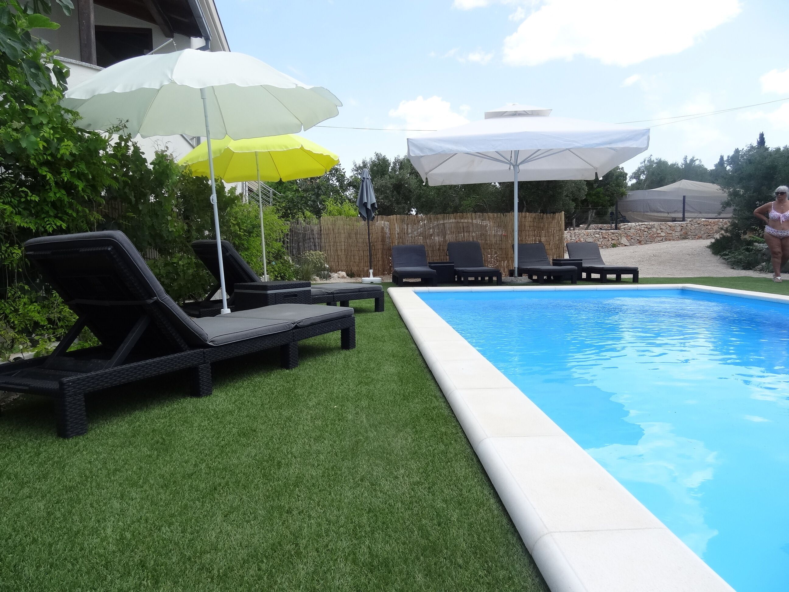 A swimming pool with lounge chairs and umbrellas.