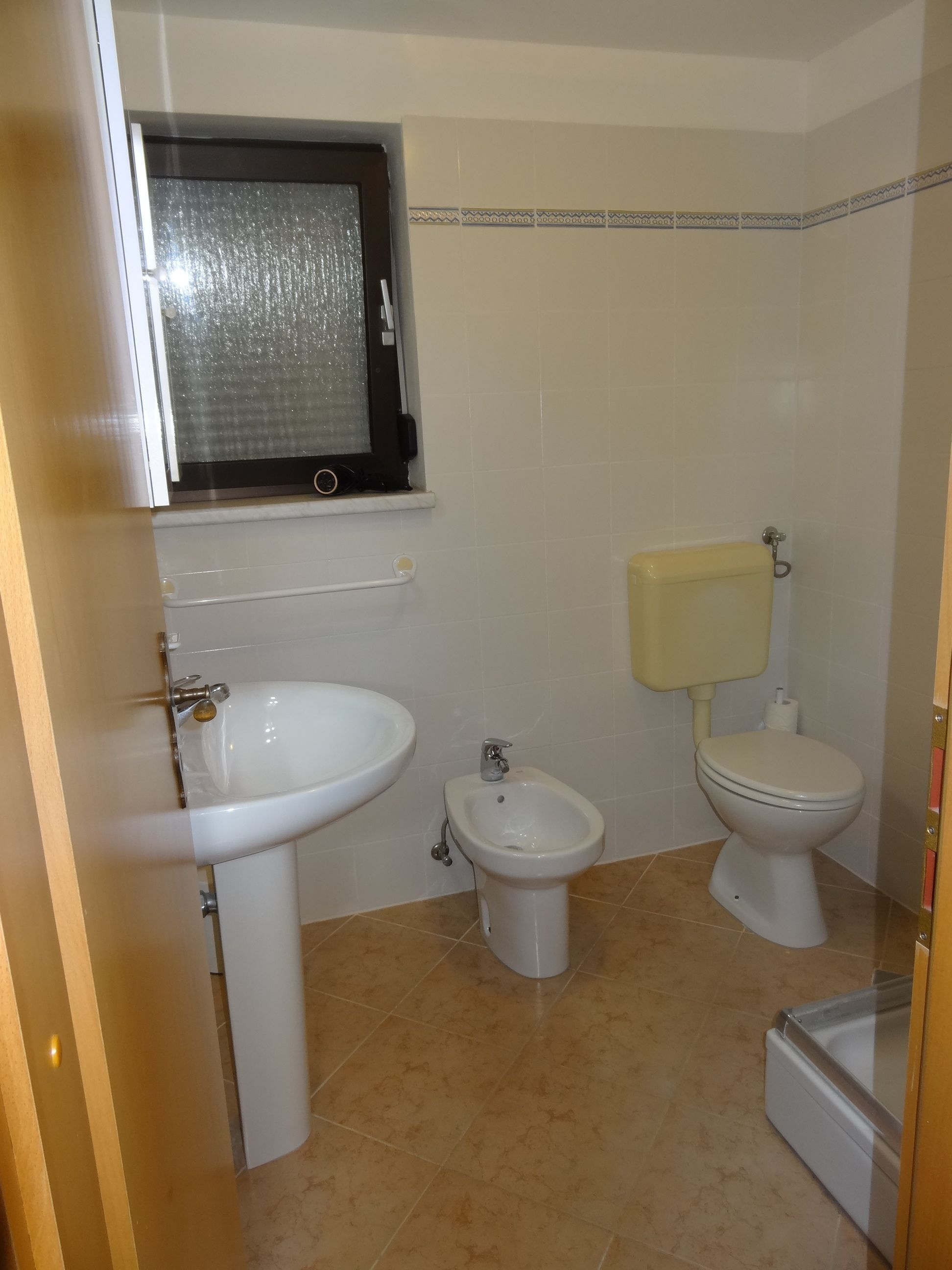 A bathroom with a pedestal sink, a bidet, and a toilet.