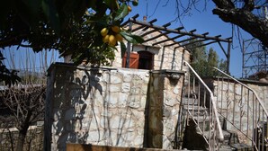 Un bâtiment en pierre doté d’un balcon en bois et d’un escalier menant à une porte.