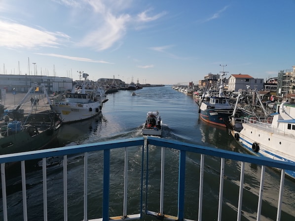 A marina with boats docked, a clear sky, and a view of the water.