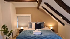 A bedroom with a bed, bedside lamps, a window, a plant, and a radiator. - Spacious And Modern 3-bedroom Near Center, Free Parking (Stavanger)