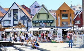A bustling outdoor market with various stalls and a crowd of people.
