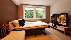 A bedroom with a bed, a TV, and a window. - Bright And Modern Apartment Near Center, 85 M2, Fully Equipped, Free Parking (Stavanger)