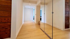 A hallway with wooden flooring, white walls, and a mirrored wardrobe. - Bright And Modern Apartment Near Center, 85 M2, Fully Equipped, Free Parking (Stavanger)