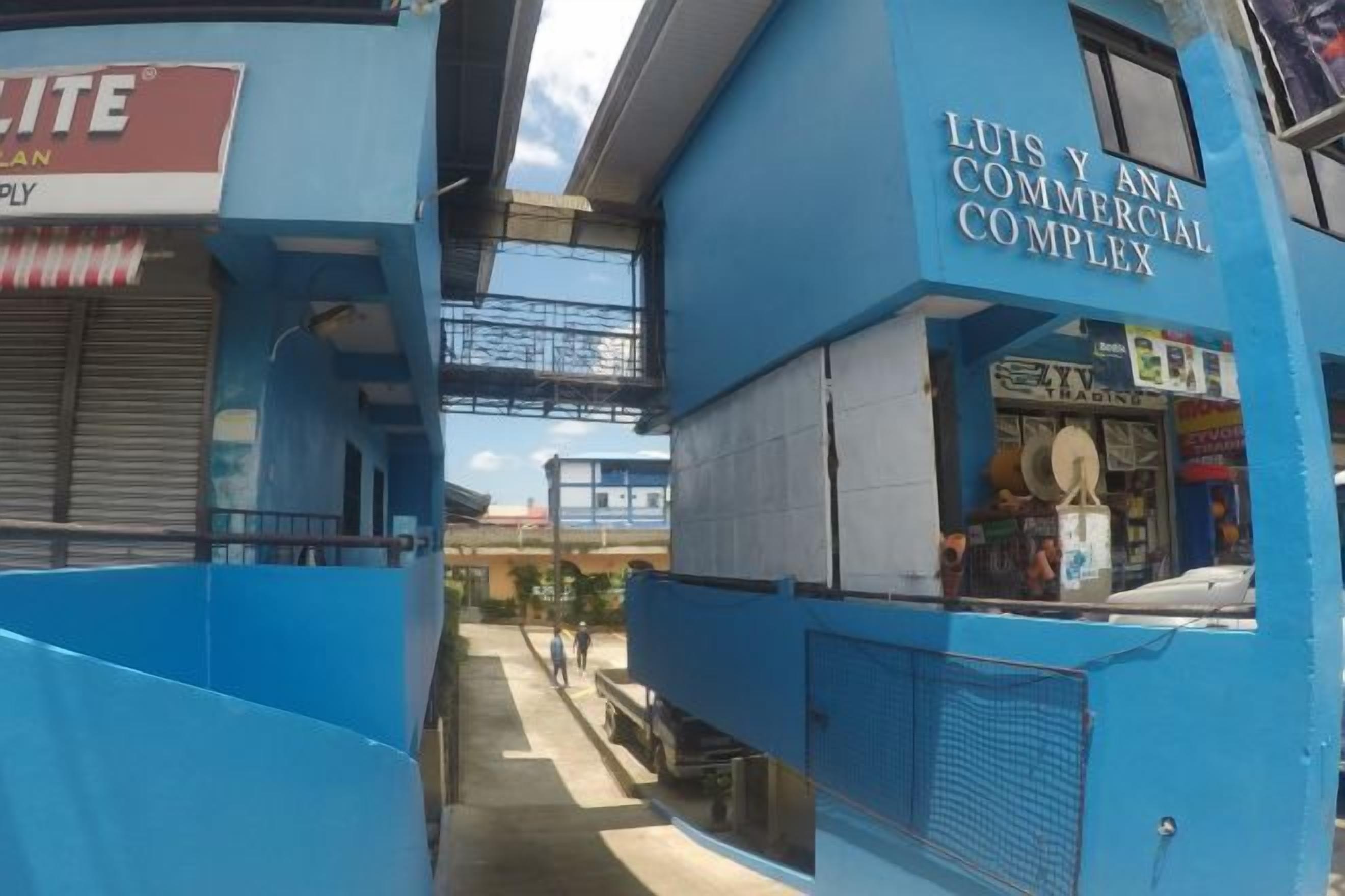 A commercial building with a sign for 'LUIS Y ANA COMMERCIAL COMPLEX' and a visible storefront.