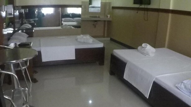 A hotel room with two single beds, a small table, and a chair. - Reddoorz Plus near Municipality of Luisiana Laguna (Luisiana)