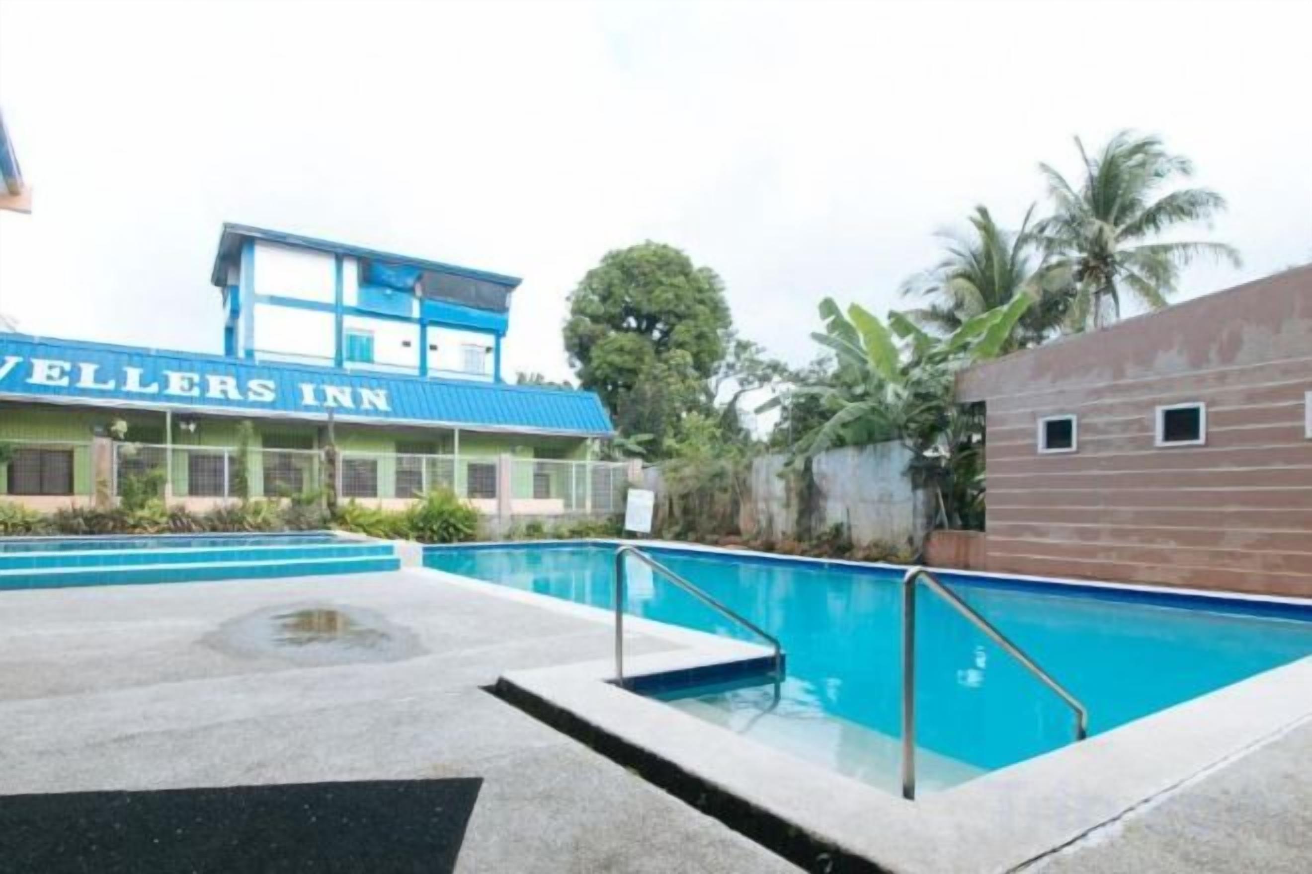 A swimming pool area with a hotel named 'Vellers Inn' in the background.