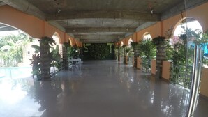 An indoor area with a polished floor, arches, and potted plants. - Reddoorz Plus Near Municipality of Luisiana Laguna (Luisiana)
