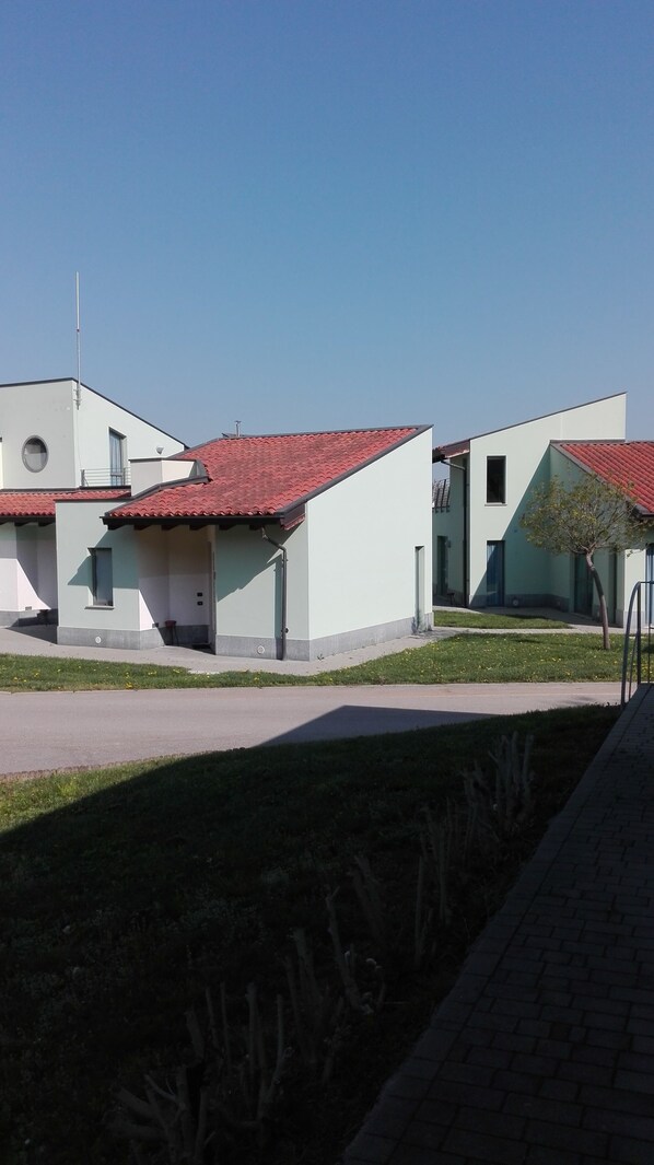 A modern building with a red-tiled roof, a flat facade, and a small window. - Room in Holiday House - Albavillage - Apartment for 2 People (Alba)