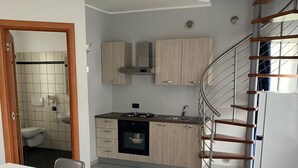 Ein kompakter Wohnraum mit Küche, Essbereich und einer Treppe.
