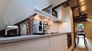 Une cuisine moderne équipée d’un four encastré, d’une machine à café et d’un grille-pain.