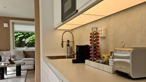 A modern kitchen with a built-in oven, a coffee machine, and a fruit basket. - Bright And Modern - 2-bedroom, Central, Free Parking (Stavanger)