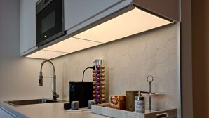 A modern kitchen with a stainless steel sink, a built-in oven, and a hexagonal tile backsplash. - Bright And Modern - 2-bedroom, Central, Free Parking (Stavanger)