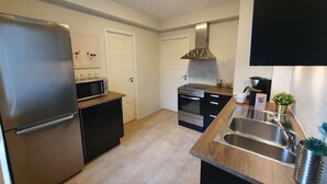 Een moderne keuken met roestvrijstalen apparatuur, een inbouwoven en een groot kookeiland met spoelbak.