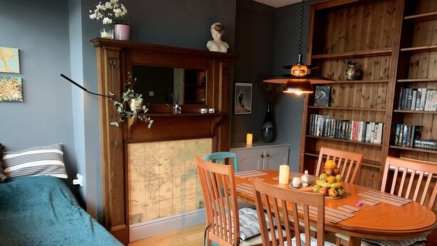 A cozy room with a wooden dining table, chairs, and a bookshelf filled with books. - Cosy Cottage Sleeps 6 Suit Families, Contractors, Couples (Chesterfield)