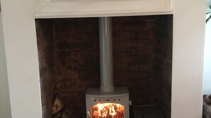 A fireplace with a white mantel, a brick wall, and a white heater below. - Cosy Cottage Sleeps 6 Suit Families, Contractors, Couples (Chesterfield)