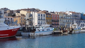 Un port où des bateaux sont amarrés, avec des bâtiments aux couleurs vives en arrière-plan.