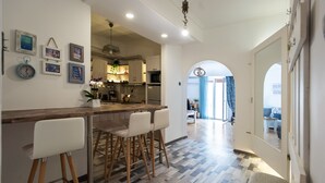 Una cocina moderna con barra, suelo de madera y vistas al comedor.