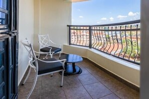 Enjoy the view from this balcony with a table and chair.
