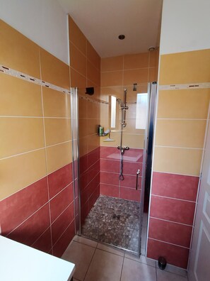 Een douche, een haardroger, handdoeken, toiletpapier