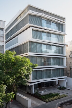 A modern multi-story building with large windows and a flat roof.