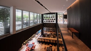Eine moderne Bar mit hoher Decke, großen Fenstern und vielfältigen Sitzmöglichkeiten.