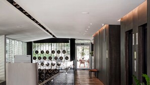Eine moderne Lobby mit Fischgrat-Holzboden, einer Rezeption und einer Wand mit runden Nummernschildern.