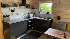 A compact kitchen with a window, built-in appliances, and a small dining area.