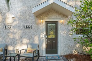 Stylish entrance with a welcoming chair and address plaques.