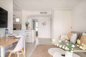 Un espace de vie moderne comprenant un coin repas, une cuisine et un coin salon.