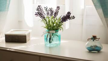 Vista clara de una habitación con un escritorio blanco, un jarrón con flores y un pequeño adorno de vidrio.