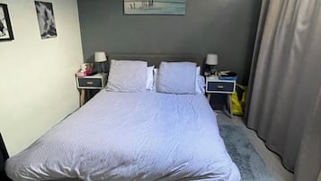 2 habitaciones, escritorio y tabla de planchar con plancha