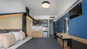 A modern hotel room with a bed, a desk, a mirror, and a kitchenette. - Pidna (Dio-Olympos)