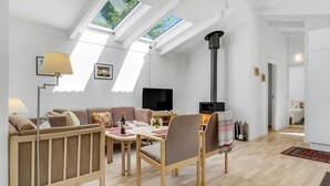 Una sala de estar moderna con sofá, sillones, televisor y chimenea.