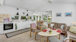 Un salón amplio con cocina, una mesa de comedor y un sofá.